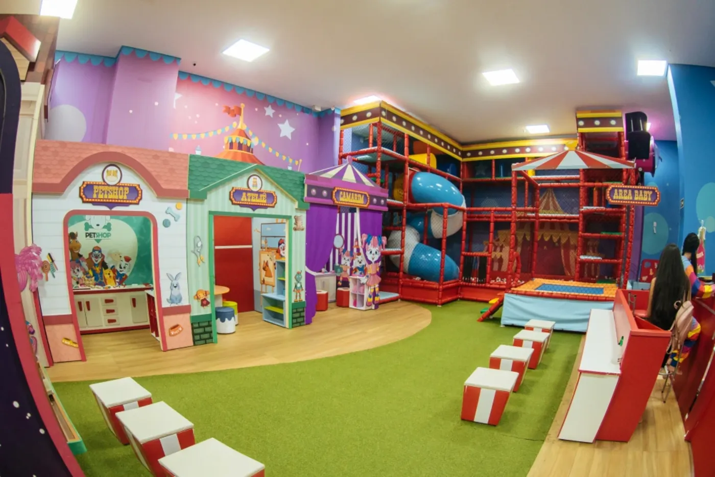 Buffet infantil com cenografia temática, brinquedão em estrutura tubular e piso em grama sintética